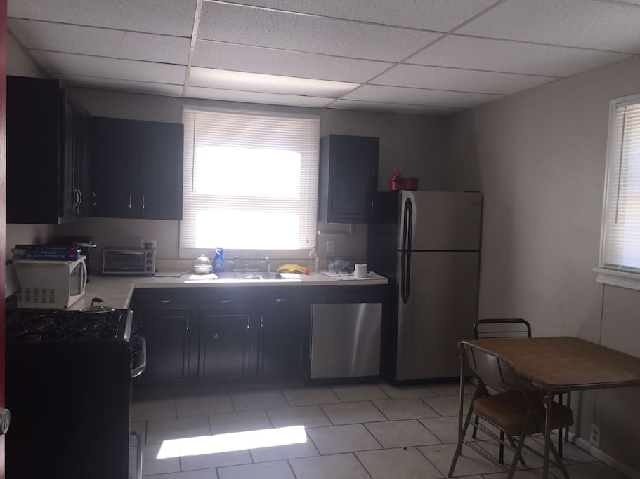Kitchen with small dining table, dishwasher, fridge