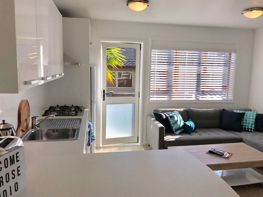 Living area with kitchenette and breakfast bar. Door to small out door deck area