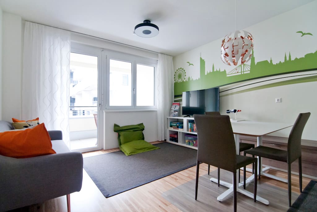 Cosy living room with 50” Netflix TV and the exit to the sunny balcony.