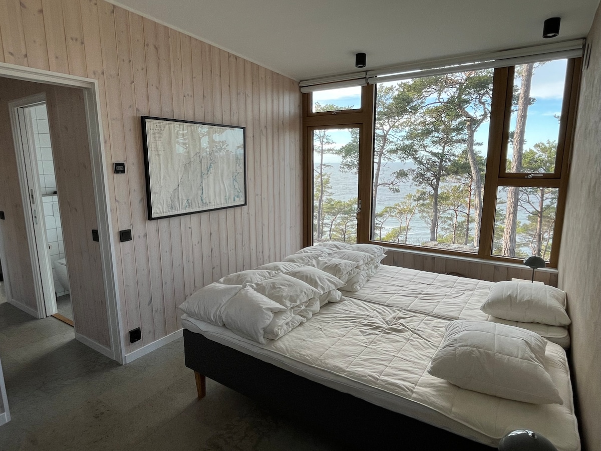 Спална соба со два единечни кревета и врата кон терасата. 