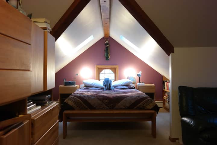 Spálňa na druhom poschodí s manželskou posteľou a samostatnou posteľou.