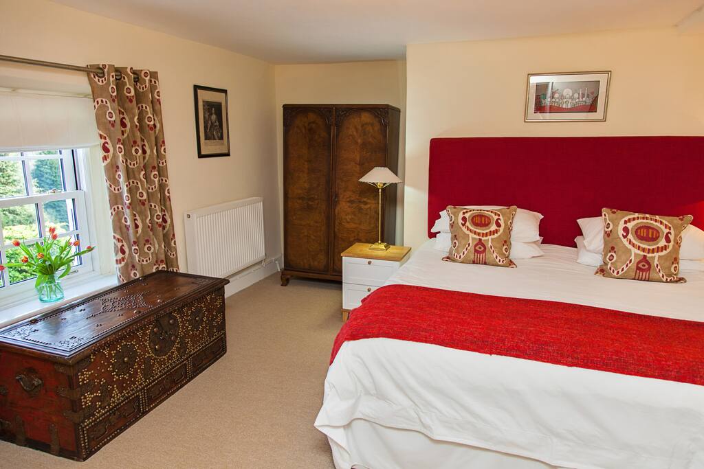 Master bedroom with Super king size bed. En-suite includes large shower and tub. Views over the gardens and valley.