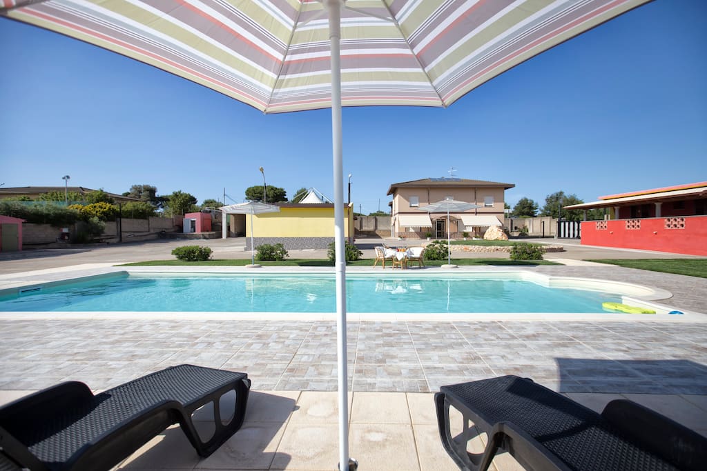 piscina esterna con sdrai ombrelloni