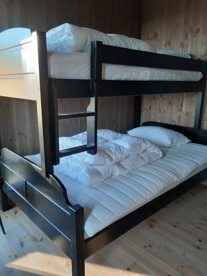 سرير عائلي في غرفة نوم في الطابق الأول. إطلالة صباحية جميلة على طرف Hardangervidda. تحتوي الغرفة أيضًا على خزانة. 