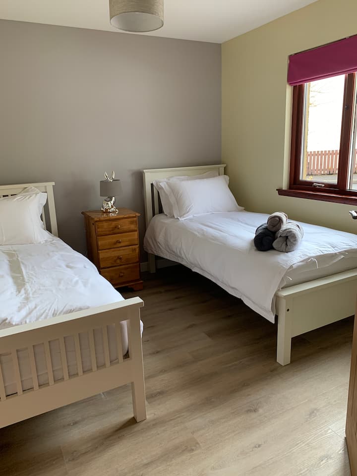 Dormitorio doble en la planta baja con colchones cómodos, ropa de cama de lujo, armario y almacenamiento de cajones