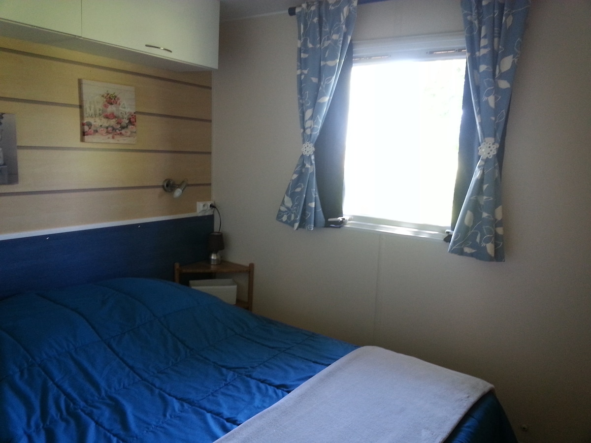 Двоен кревет во спална соба со директен пристап до бањата