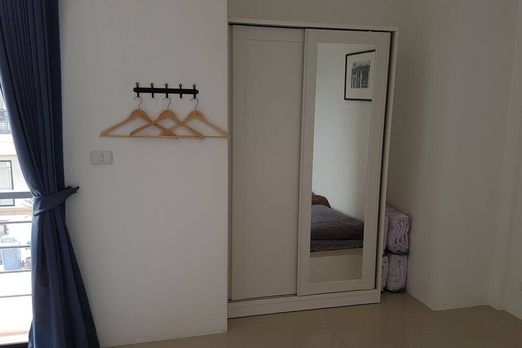 A closet and clothes hangers in the mater bedroom for 4 people.