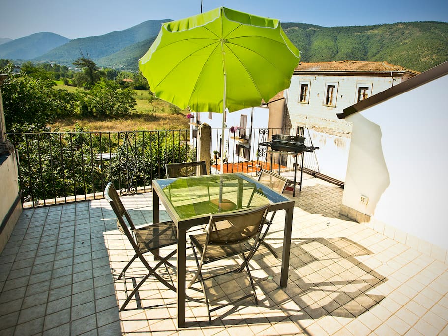 View off of the terrace, with barbecue, table and parasol.