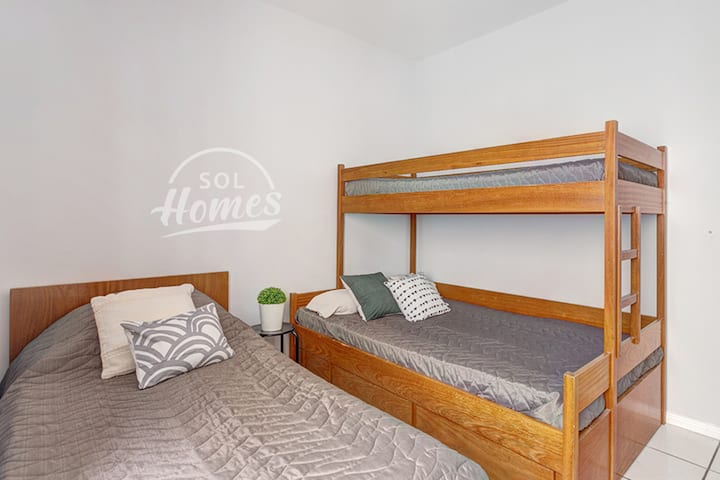 Chumba cha kulala kina kitanda kimoja na kitanda cha ghorofa (sehemu ya chini ya kitanda cha ghorofa ni kubwa).