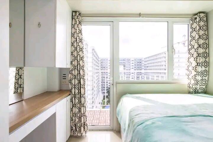 إطلالة كاملة على غرفة النوم مع خزانة ملابس مدمجة ومرآة زينة وطاولة/درج