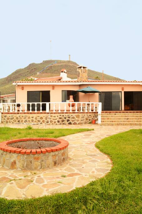 Expansive patio and grassy area with fire pit and ocean views