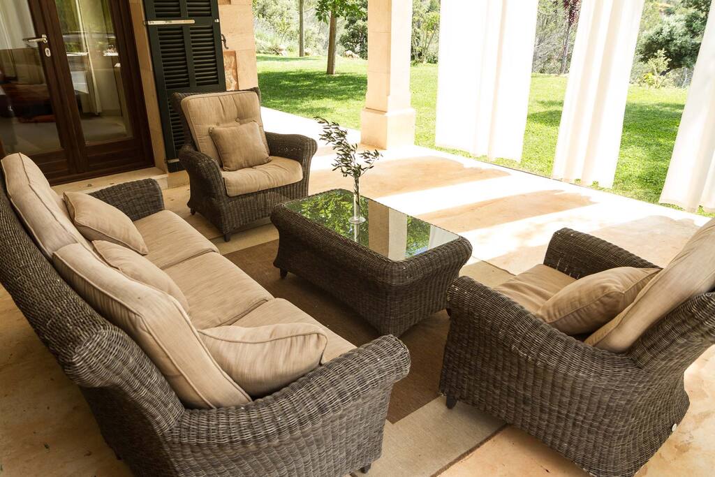 Rincón del jardín resguardado del sol con cortinas y cómodos sofás de exterior