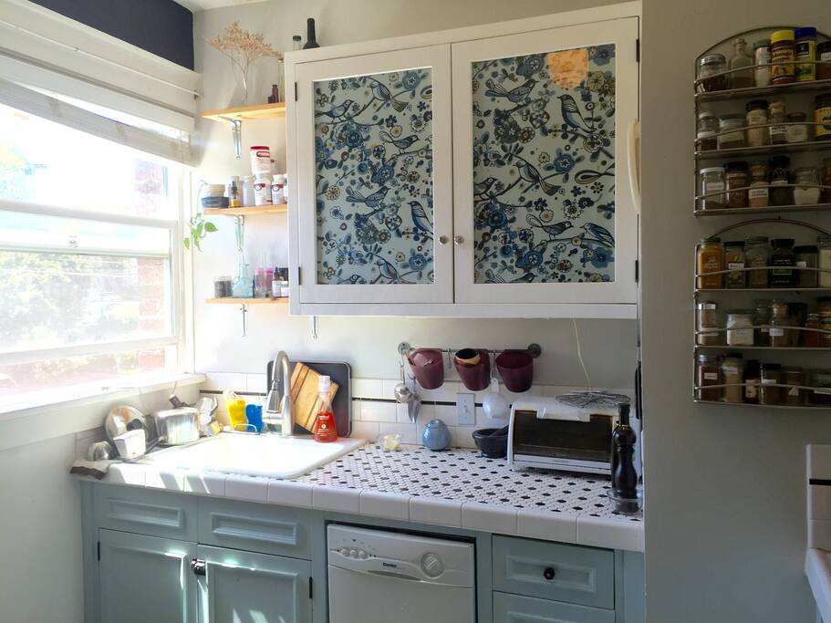 Bright kitchen with farmhouse sink, gas stove, dishwasher, and full size refrigerator.