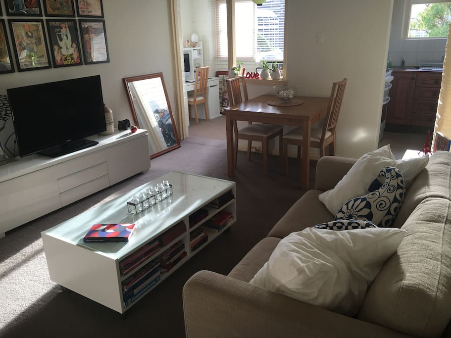 Living room with extendable dining table, TV, PS4 and books and magazines.