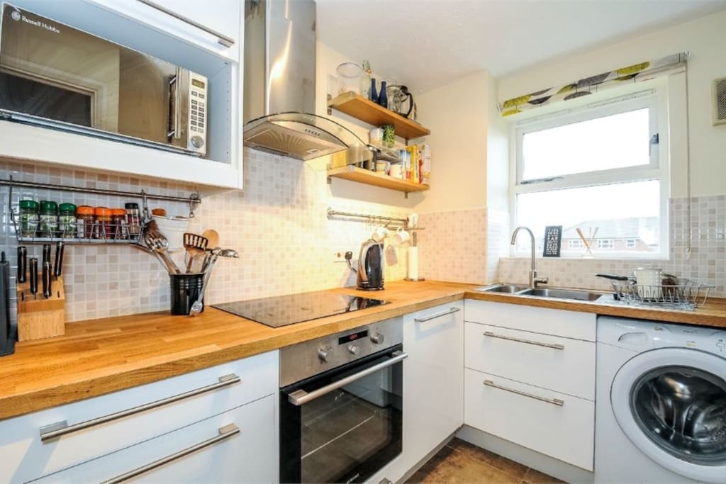 Modern kitchen with washing machine and dishwasher and cooking equipment