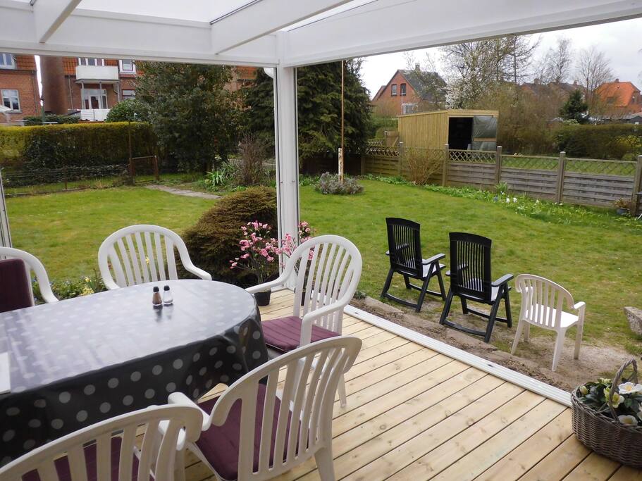 Overdækket terrasse med møbler til dejlig lille have mod syd