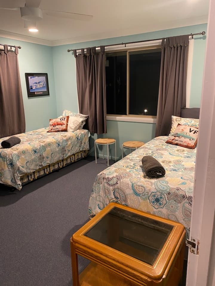 غرفة نوم في الطابق العلوي مع سريرين فرديين. واحد لديه درج قابل للطي. مروحة سقف.