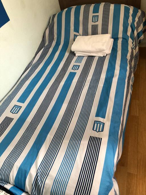 Cama individual , mueble para la ropa , toallas para uso personal .