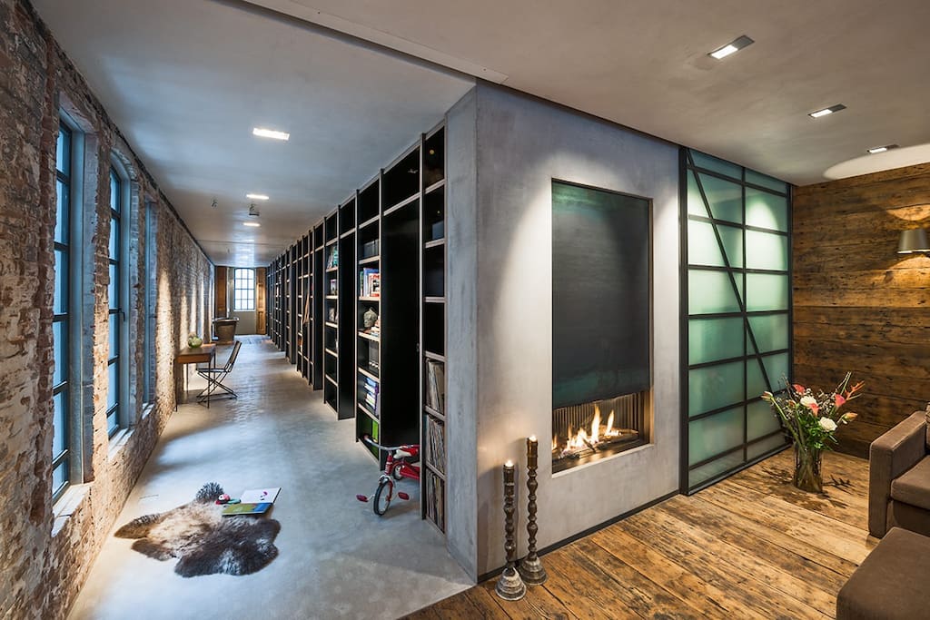 Wide hall way with a 16 meter long book shelf, with entrances to bed and bathrooms