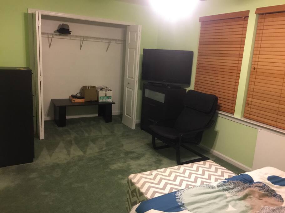 View of TV, two dressers and closet