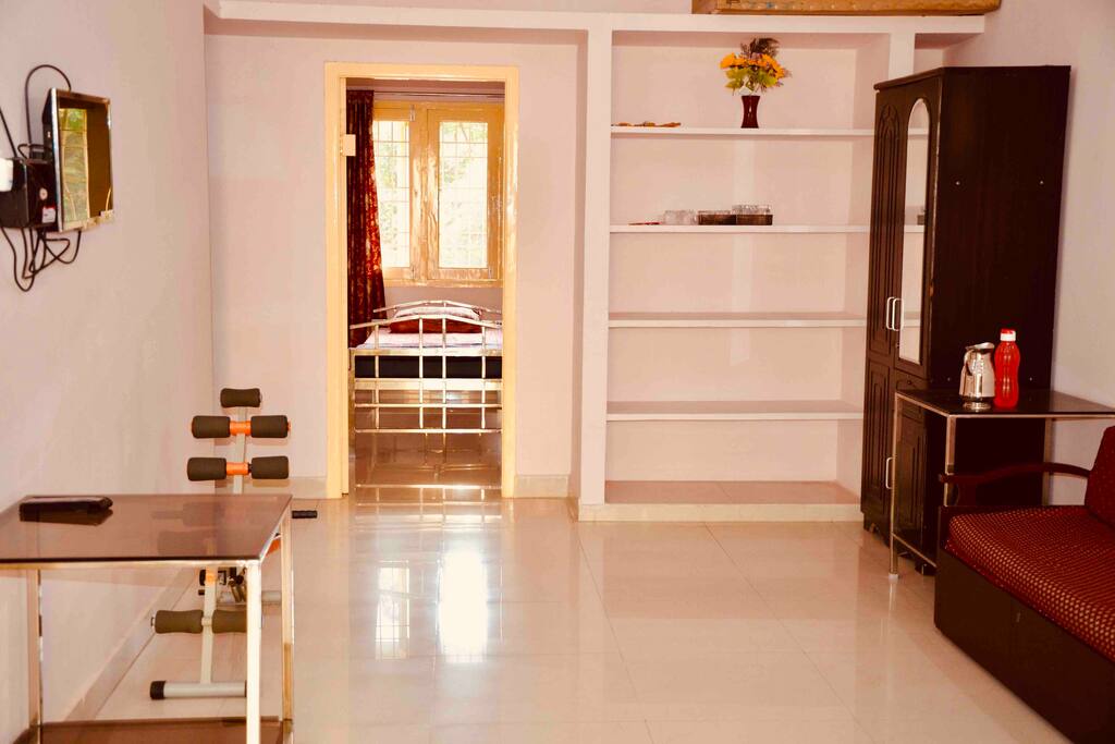 Living room consists of a dining table, a sofa and a wardrobe and a TV