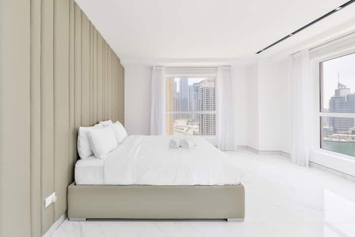 A private bedroom space with large window panes that fill the room with ample daylight