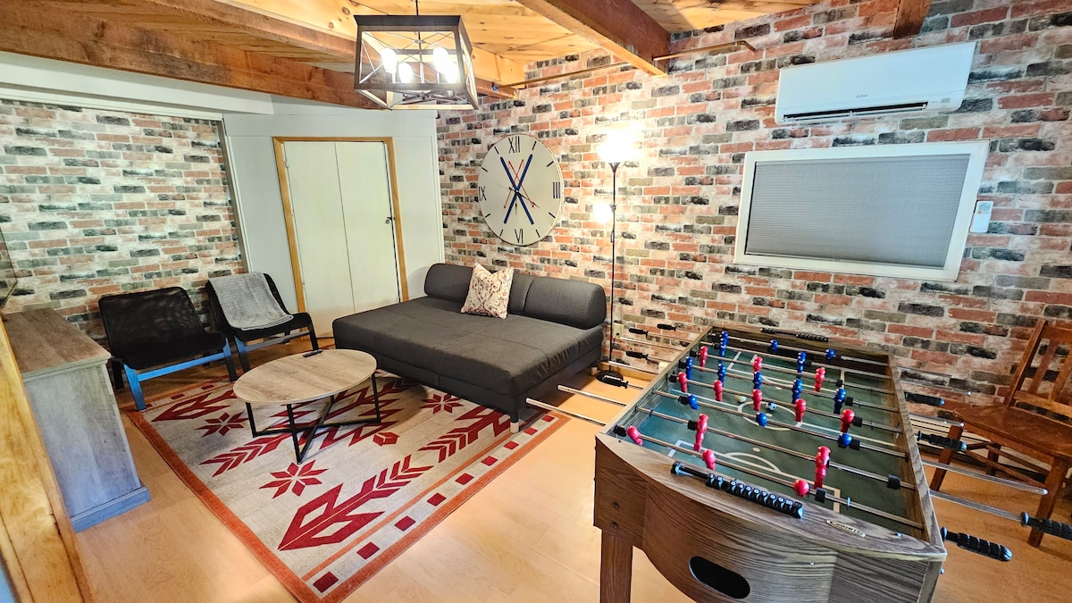 Dnevni boravak u prizemlju s društvenim igrama, stolnim nogometom i pametnim televizorom. Sofa se udvostručuje kao madrac u punoj veličini. Čaršafe, deke i jastuke možete pronaći tako da podignete trake na prednjoj strani okvira i otvorite ih.