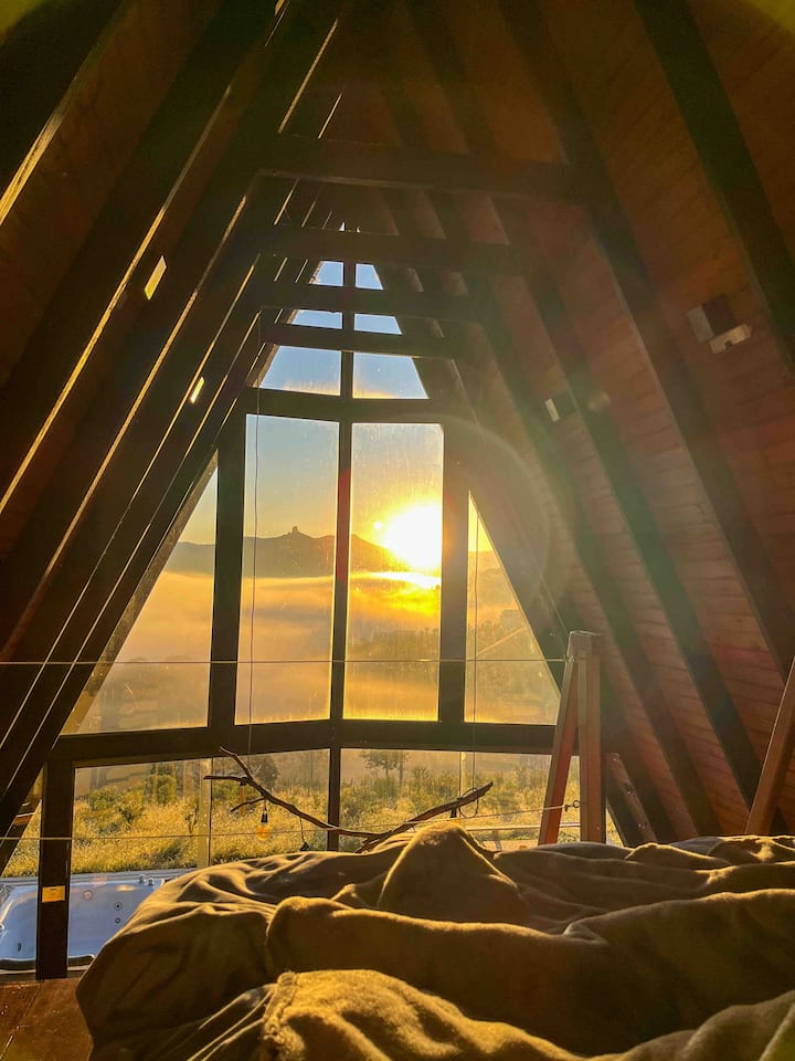Quarto com cama de casal com vista para as montanhas, vista para o nascer do sol