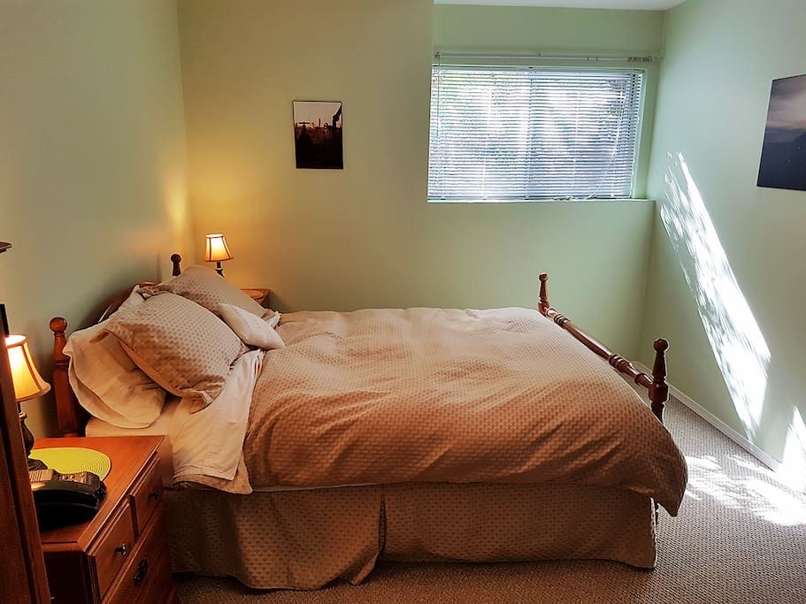 Your private bedroom with queen-size bed and cozy linens. (Garden outside the window)