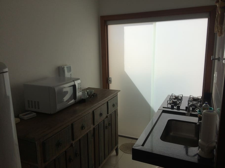 Cozinha com fogão, micro-ondas, geladeira.