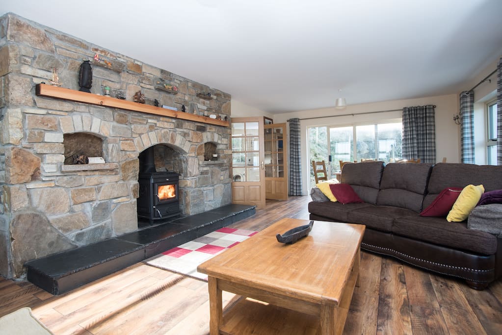 Sitting room with Stonework fireplace and stove.