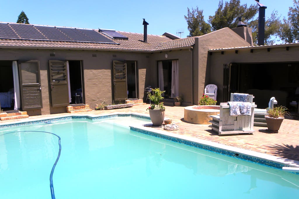 pool with bedroom doors and entertainment area flowing from it