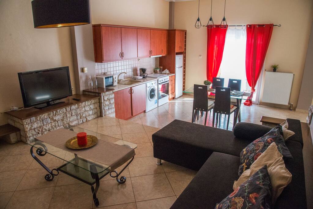 The main living room with tv and fireplace and the kitchen at the back.