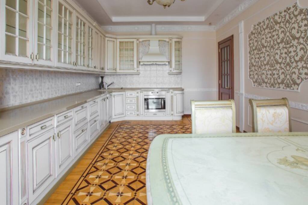 Kitchen with dishwasher, microwave, oven, fridge and big dining table