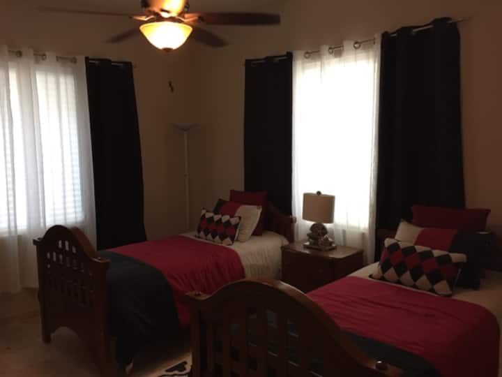 לחדר שינה שני עם שתי מיטות יש חדר  רחצה צמוד