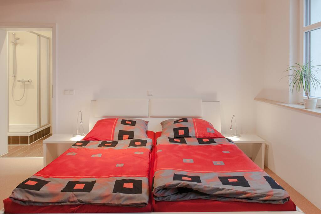 Blick auf das 1.80m x 2.00m Doppelbett mit kompfortablen Dunlopillo-Matratzen.