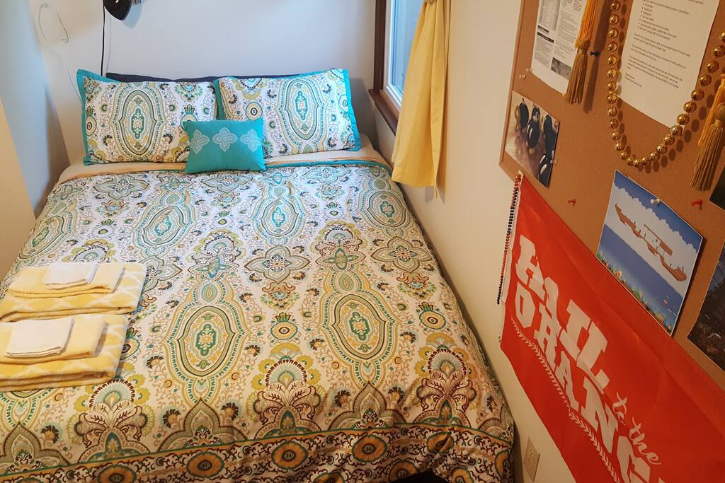Queen mattress on platform bed with 1.5 inch foam mattress topper. Easy open window for fresh breeze and multiple pillows for guest comfort. Small flexible light above the bed.