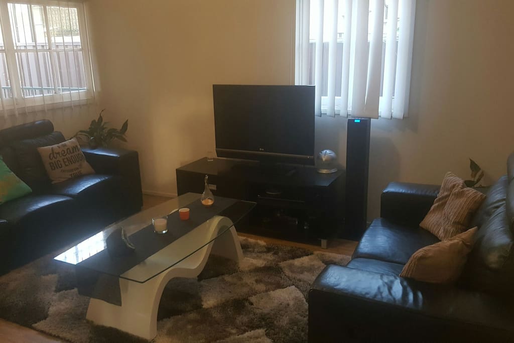 Lounge room with sofas and tv.