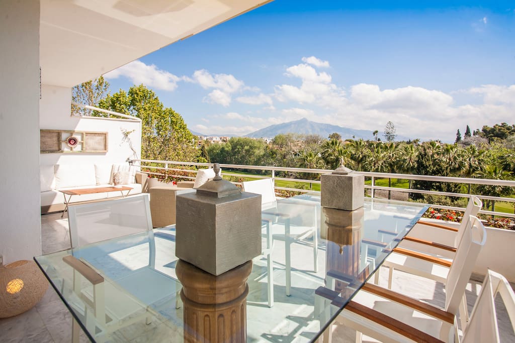 Ample terrace with outdoor dining and lounge areas overlooking Guadalmina south golf club