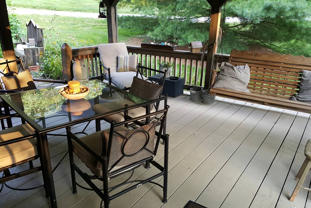 Table for 4 under covered porch with ceiling fan right next to water garden.