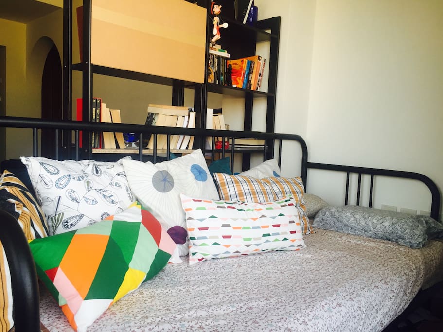 This is your cozy daybed, it has a good view on the balcony and it's separated by the library from the living room.