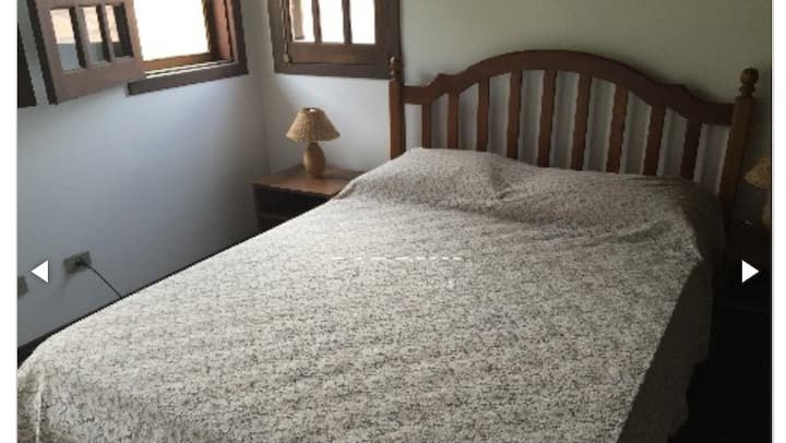 חדר קומת ביניים עם מיטה זוגית ומאוורר תקרה.