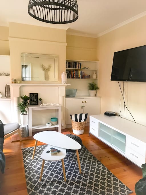 TV is now wall mounted with updated coffee table but same furnishings throughout.