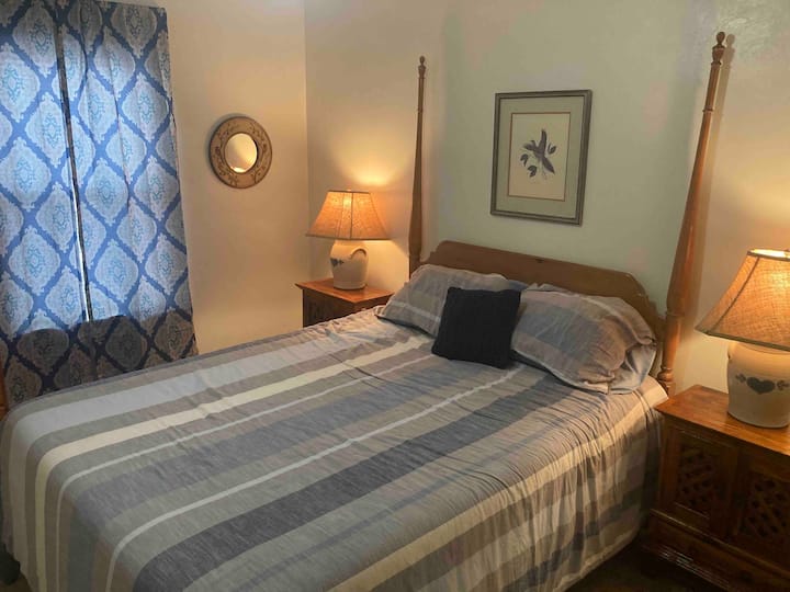 Väčšia spálňa s manželskou posteľou a stoličkou na čítanie. 