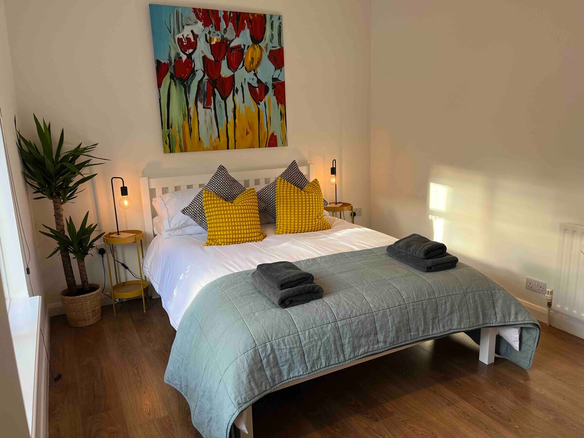 غرفة نوم رئيسية مزدوجة مع سرير بمقاس بمقاس وخزانة ملابس وصدر من الأدراج. 