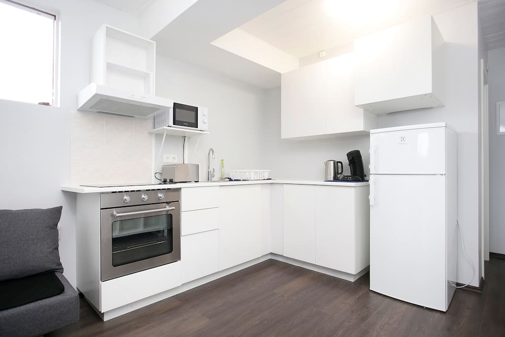 Kitchen has new oven, induction stove, refrigerator, microwave, toaster, coffee machine and kettle.
