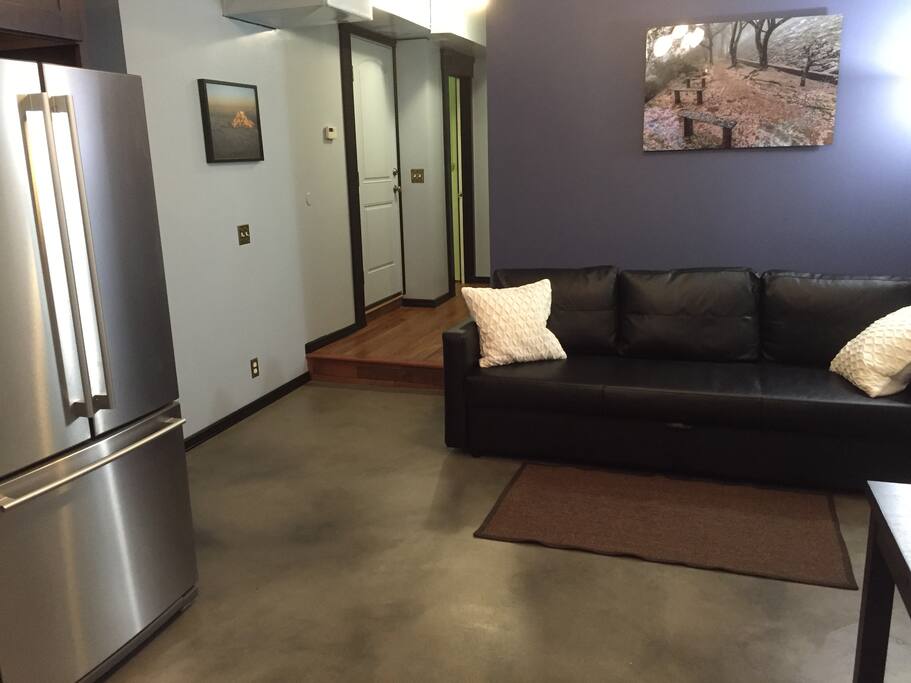 Kitchen/living room with view of hallway to bedroom and laundry room