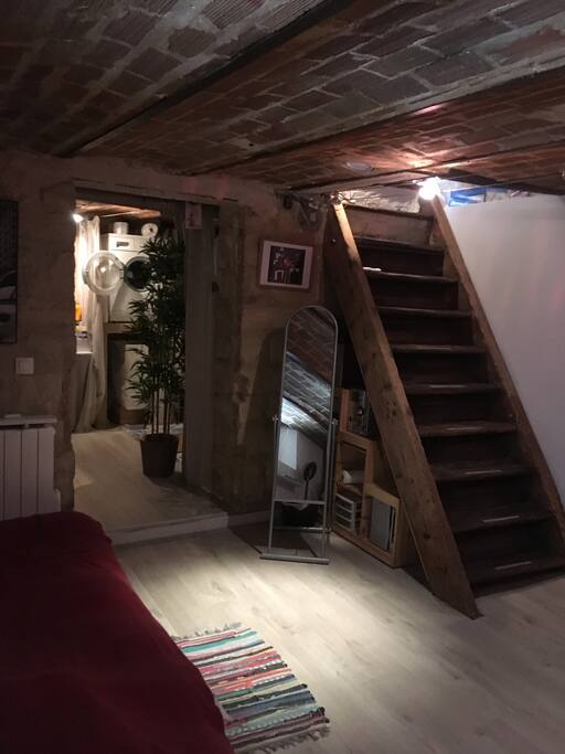 Escalier menant à la cuisine, au fond, la salle d'eau