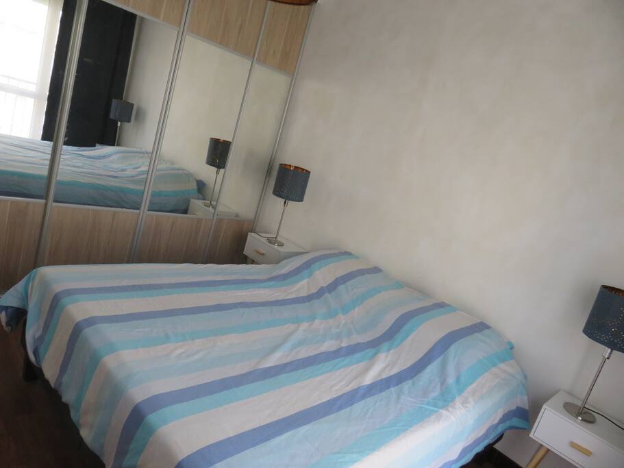 Grande chambre lumineuse avec grand lit, placard et balcon.