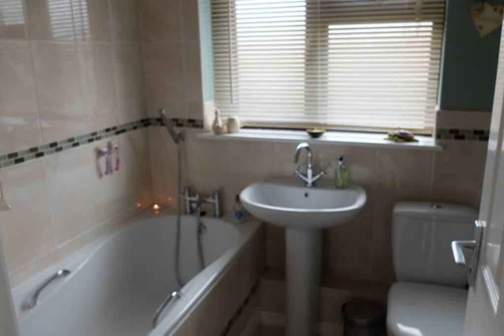 private bathroom with bath and shower head